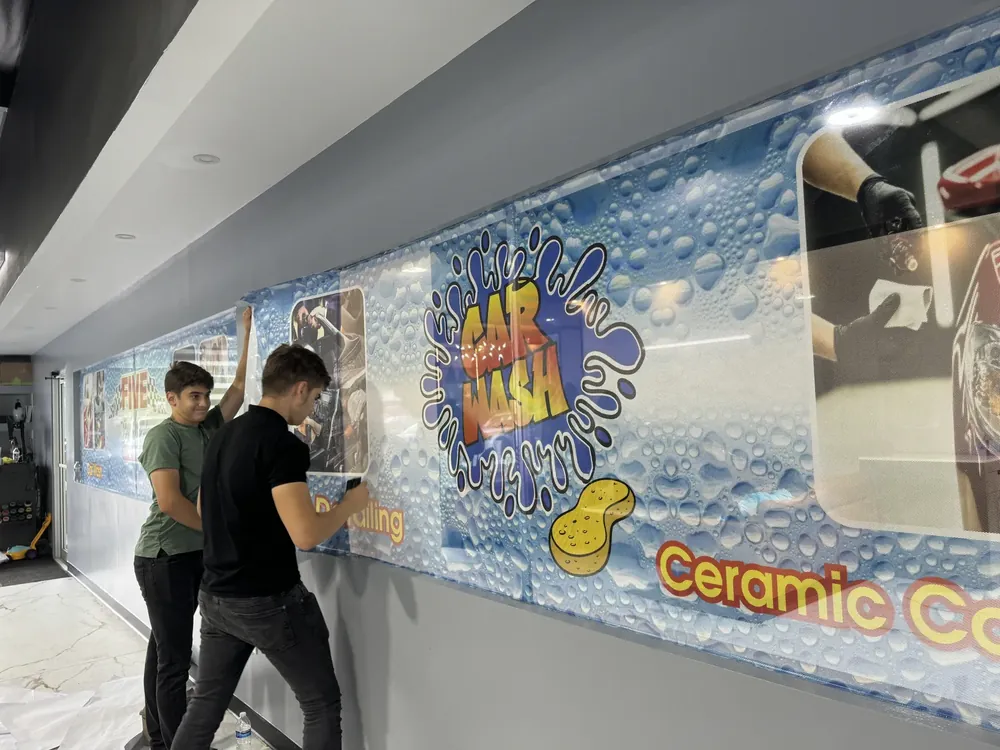 Printed wall mural being installed inside a car wash
