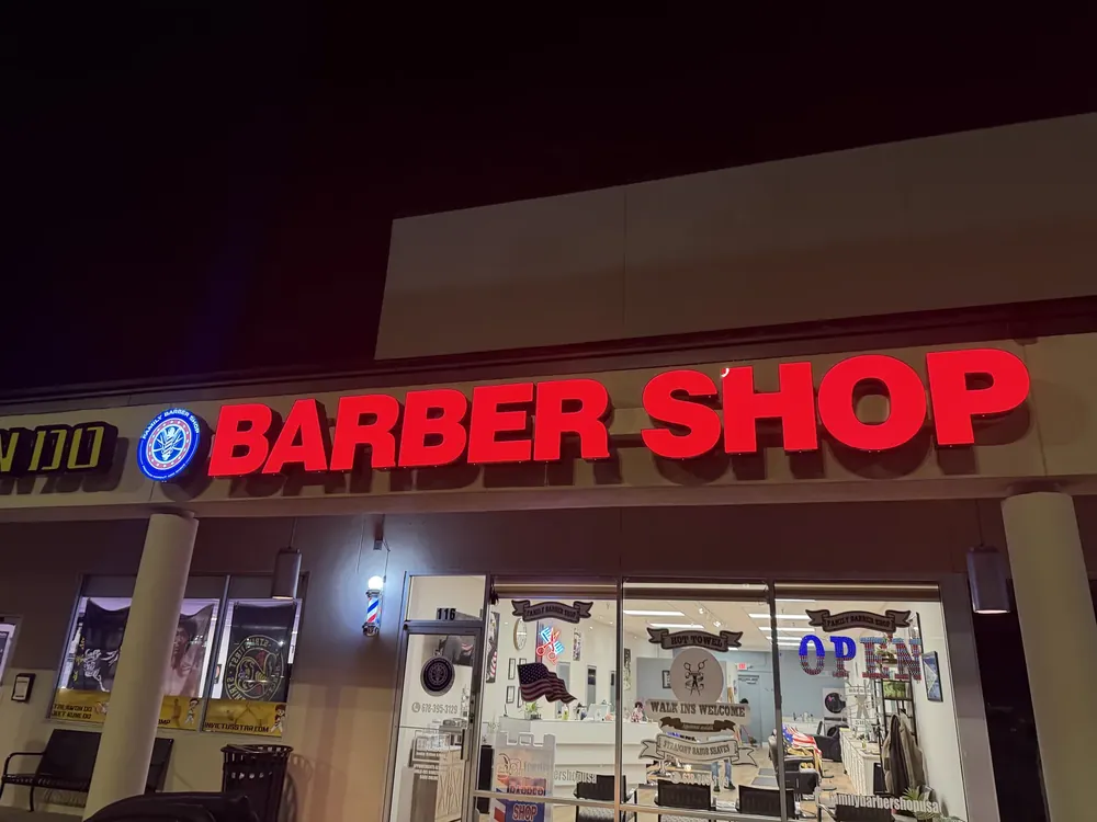 Illuminated red barber shop letters at night