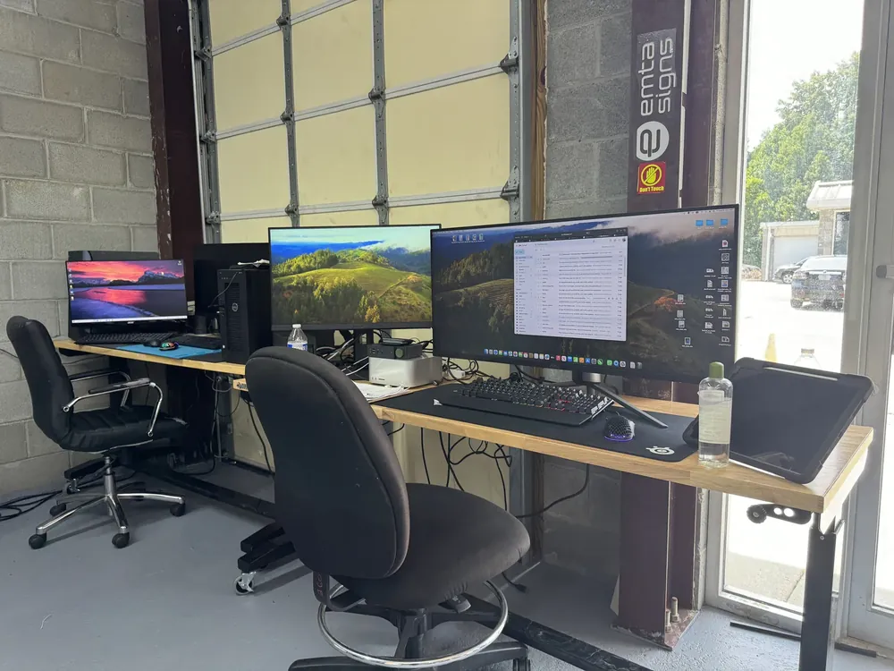 Sign designer working at a multi-monitor workstation