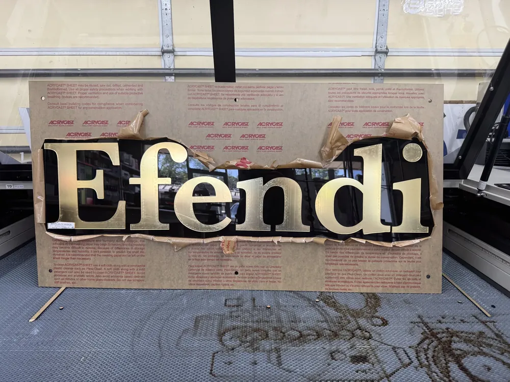 Gold Efendi channel letters laid out in the shop